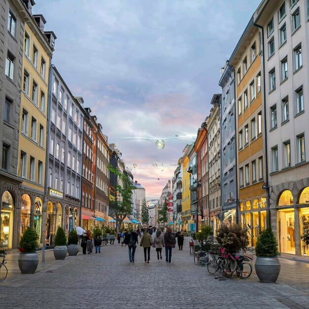 La gente cammina lungo una strada commerciale verso Marienhof a Monaco di Baviera alla sera della Germania