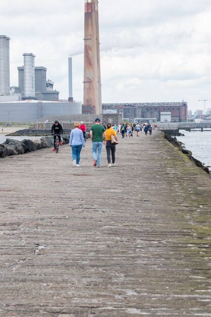 La gente cammina sulla grande passeggiata sud al faro di Pollbeg.