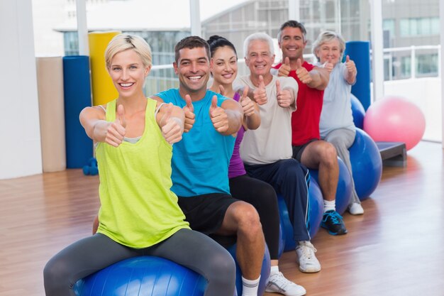 La gente che gesturing i pollici su nel club di salute