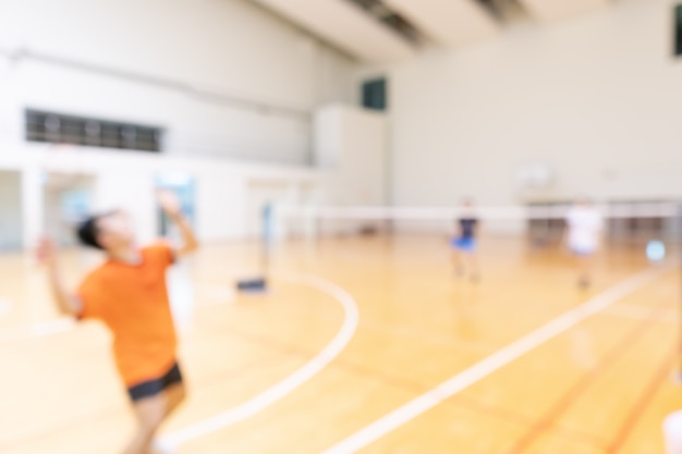 La gente che gioca a badminton in doppia squadra gioca in palestra