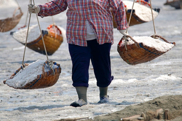 La gente che lavora al giacimento del sale in Tailandia