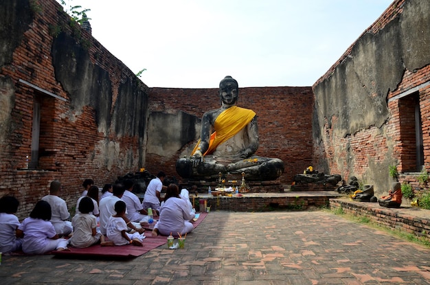 La gente che prega con la statua del buddha al tempio di Wat Worachet Tharam il 10 gennaio 2016 ad Ayutthaya Tailandia