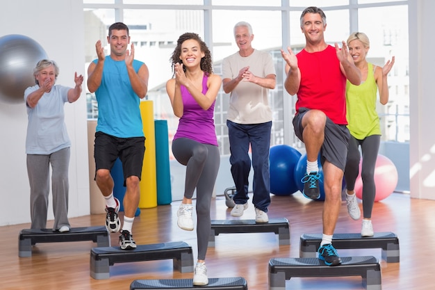 La gente che si esercita di aerobica di punto in palestra