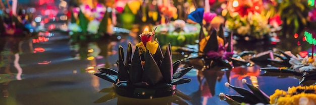 La gente del festival Loy krathong compra fiori e candele da accendere e galleggia sull'acqua per celebrare il loy