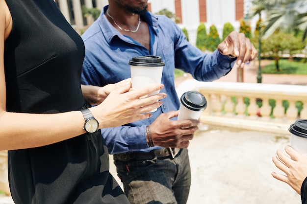 La gente di affari che cammina con elimina il caffè