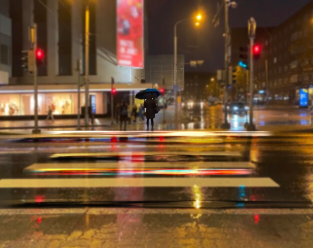 la gente di strada piovosa cammina con gli ombrelli città luce sfocata pavimentazione bagnata Città vecchia di Tallinn