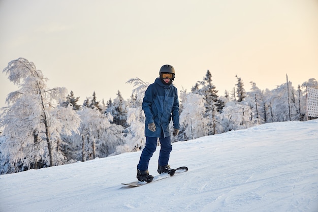 La gente fa snowboard e sci, attività ricreative invernali e sport. Sciare giù dalla montagna con lo snowboard, emozioni divertenti sui volti di uomini e donne