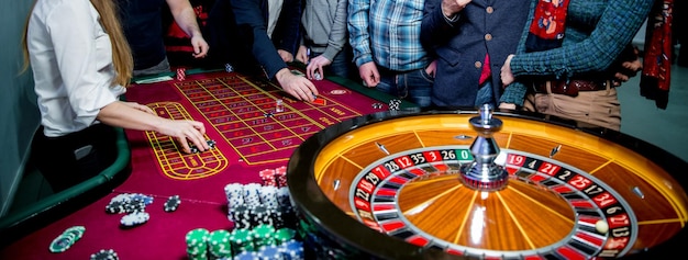 La gente gioca alla roulette del poker al tavolo Amici che giocano al casinò