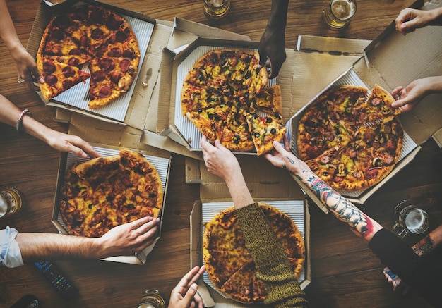 La gente passa afferrando fetta di pizza