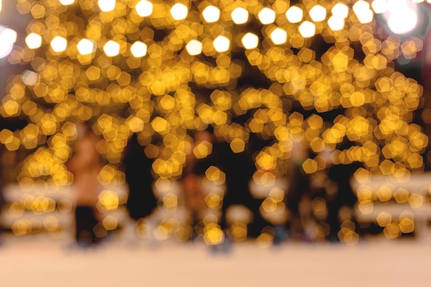 La gente sullo sfondo dell'albero di capodanno nella ghirlanda di luce di Natale ha sfocato lo sfondo dell'immagine