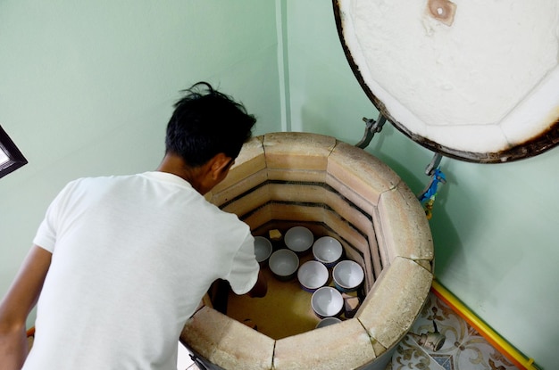 La gente tailandese woking il fuoco di processo La ceramica Benjarong è ceramica tradizionale tailandese di cinque colori di base di stile