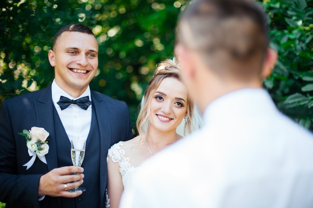 La gente tiene in mano bicchieri con vino bianco. festa di matrimonio. amici brindando con uno champagne