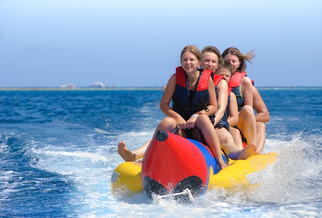 La gente va su una banana boat. Mare azzurro brillante e cielo limpido. Felici vacanze.