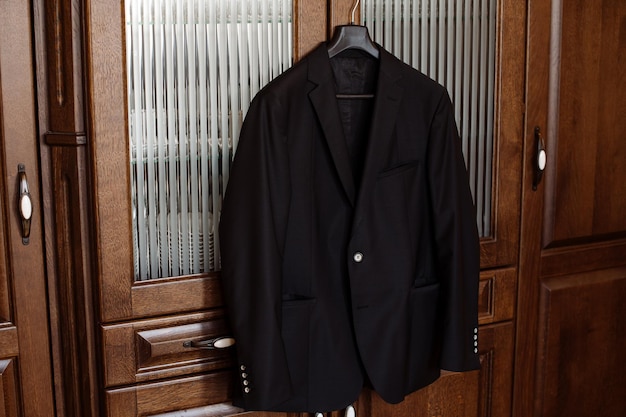 La giacca da sposo alla moda è appesa all'armadio al mattino il giorno del matrimonio