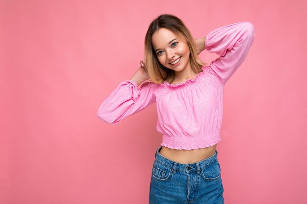La giovane bella donna alla moda donna in rosa alla moda crop top femmina positiva mostra il viso