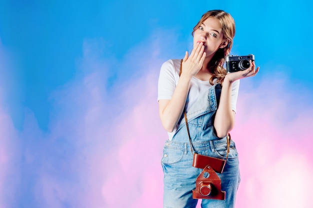 La giovane bella donna che tiene una retro macchina fotografica sta per viaggiare