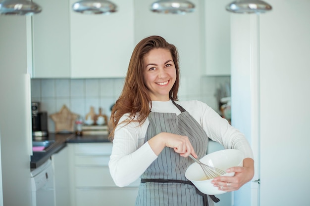 La giovane bella donna cuoce una torta. Dolci. Confetteria.