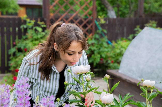 La giovane bella donna si prende cura dei fiori