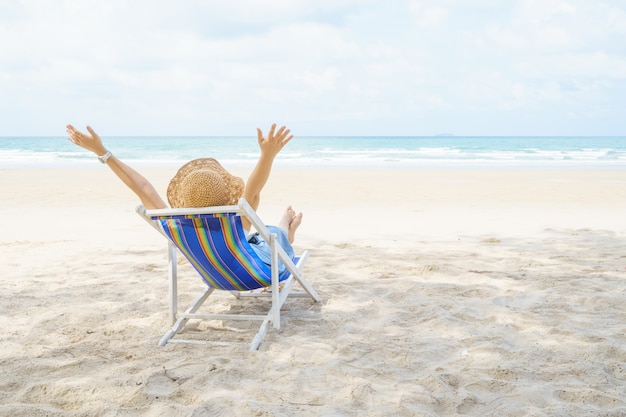 La giovane bella donna si rilassa sulla spiaggia vicino al mare