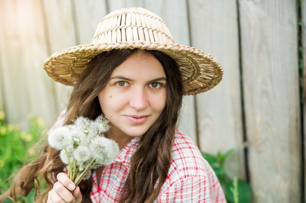 La giovane bella ragazza con i denti di leone.