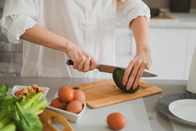 La giovane bella ragazza in cucina prepara cibo sano