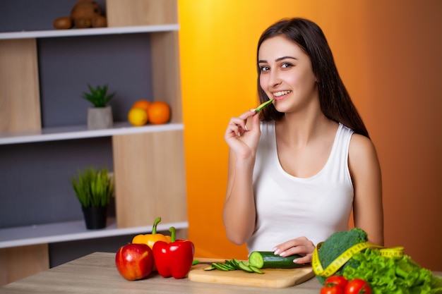 La giovane bella ragazza prepara un'insalata di dieta utile