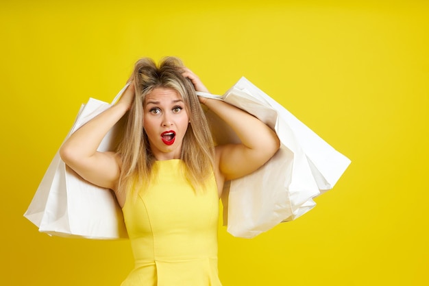 La giovane bionda grassoccia in un vestito estivo giallo le tiene la testa