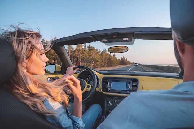 La giovane coppia che viaggia in cabriolet