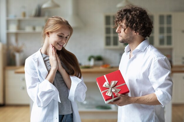 La giovane coppia felice a casa si scambia regali