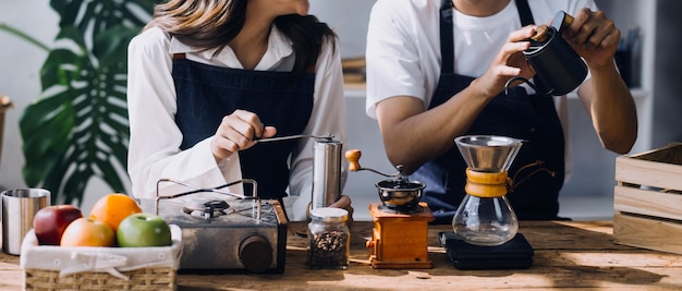 La giovane coppia felice sta godendo e preparando un pasto sano nella loro cucina e leggendo ricette sul laptop