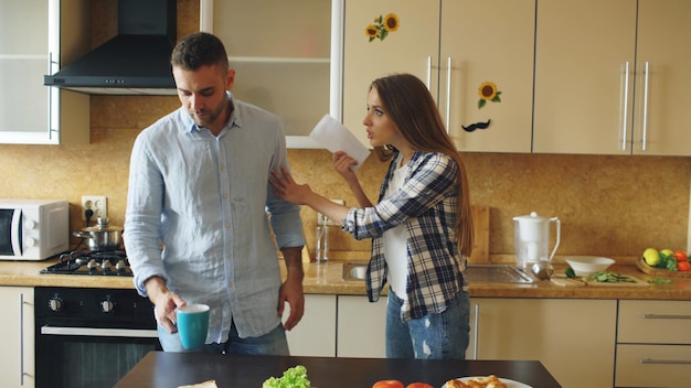 La giovane coppia litiga in cucina a casa