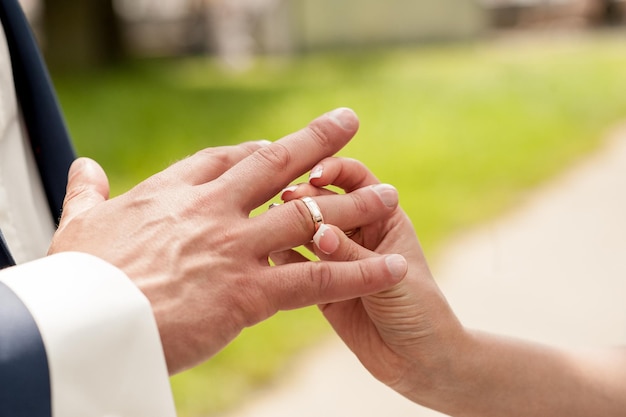 La giovane coppia mette le fedi nuziali molto romanticheAnello di fidanzamento