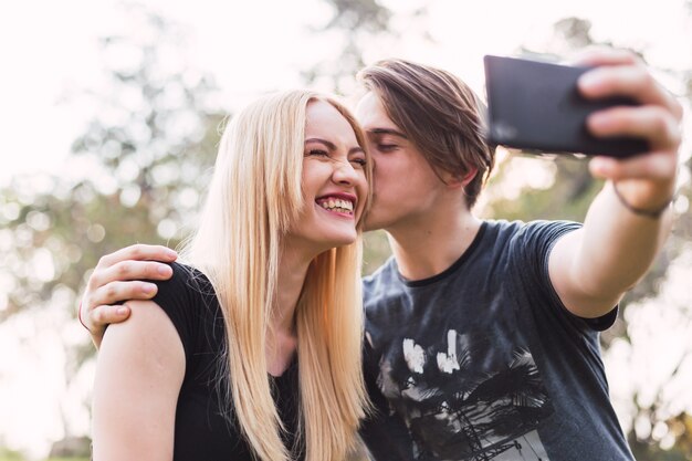 La giovane coppia prende un selfie. Coppia felice al parco.