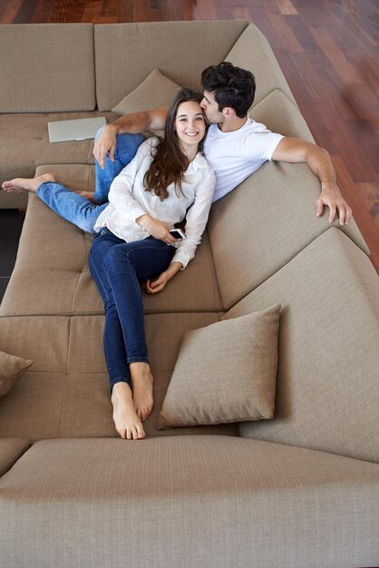 la giovane coppia romantica felice si diverte a rilassarsi sorridendo nel moderno soggiorno di casa al chiuso