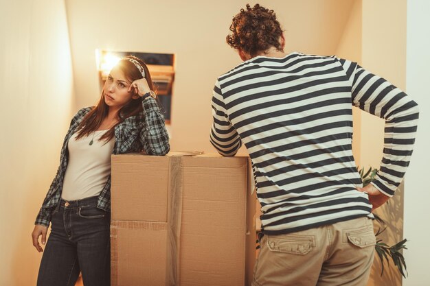 La giovane coppia si sta trasferendo in una nuova casa. Sono stanchi dopo aver portato un sacco di scatole con le cose nella loro nuova casa.