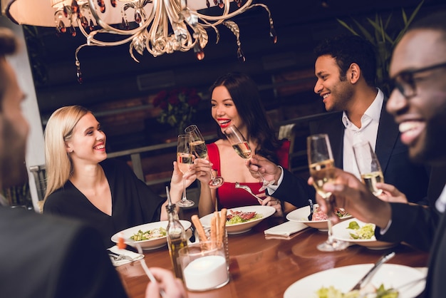 La giovane coppia sta bevendo nel ristorante con gli amici