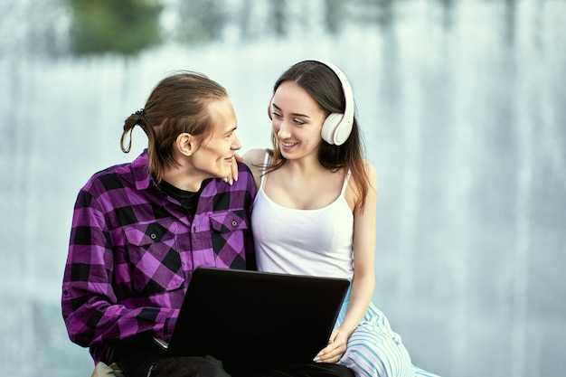 La giovane coppia usa il laptop all'aperto durante un appuntamento romantico