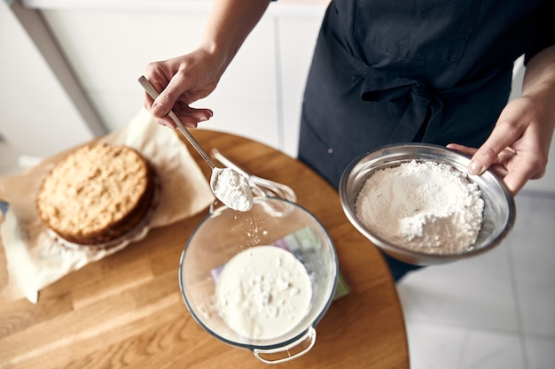 La giovane cuoca professionista sta preparando una gustosa torta nella sua cucina moderna e leggera