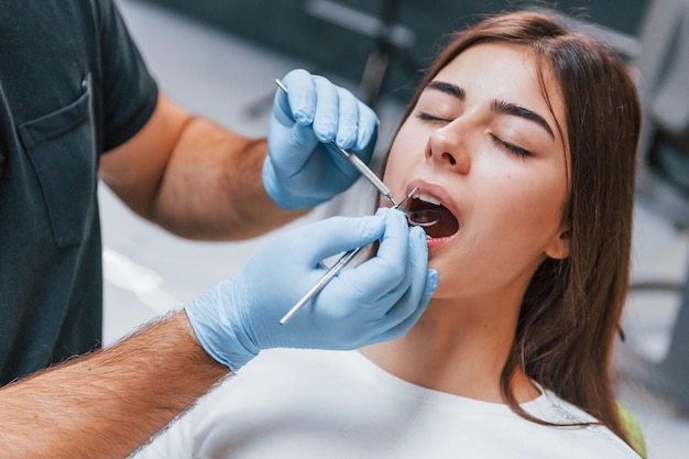 La giovane donna adulta ha una visita nella clinica del dentista. Concezione della stomatologia.