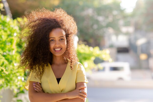 La giovane donna afro nera felice ha un sorriso sicuro di sé è in posa con i suoi capelli ricci Lo spazio di copia include