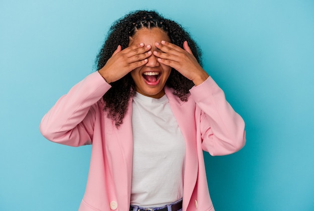 La giovane donna afroamericana copre gli occhi con le mani, sorride ampiamente in attesa di una sorpresa.