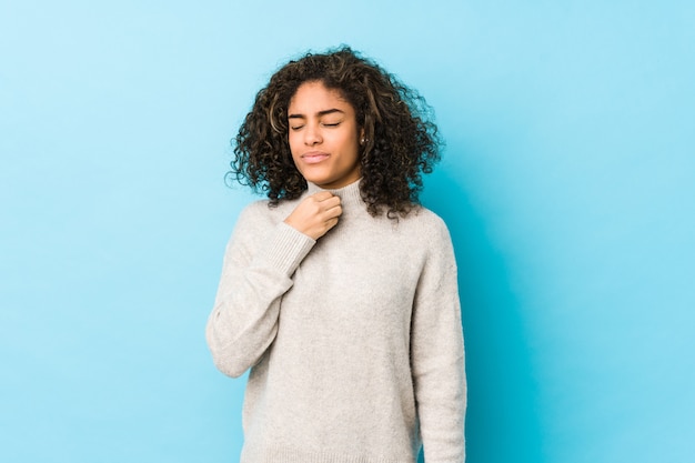 La giovane donna afroamericana dei capelli ricci soffre di dolore alla gola a causa di un virus o un'infezione.