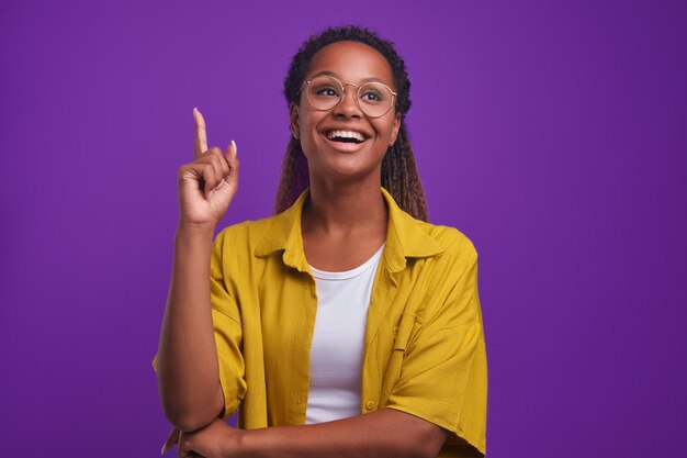 La giovane donna afroamericana intraprendente sorride e alza il dito