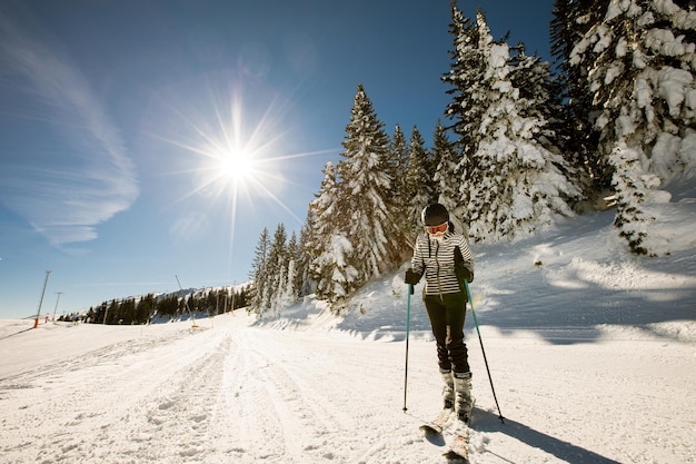 La giovane donna alla beatitudine dello sci invernale un'avventura di una giornata di sole