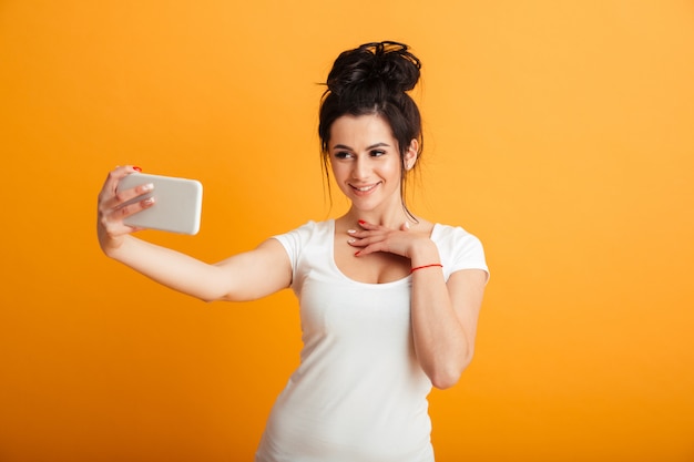 La giovane donna allegra fa il selfie dal telefono cellulare.