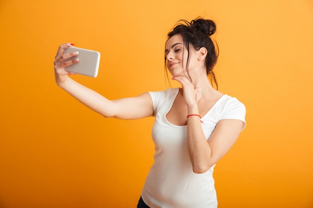 La giovane donna allegra fa il selfie dal telefono cellulare.