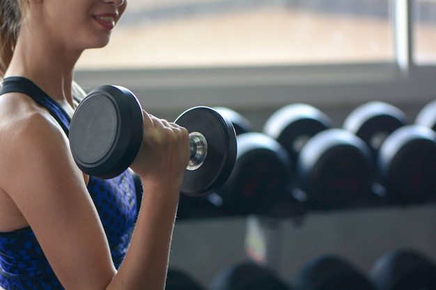 La giovane donna alza la testa di legno, concetto di forma fisica della palestra.