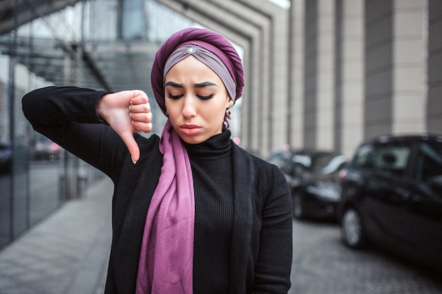 La giovane donna araba triste e turbata sta fuori.