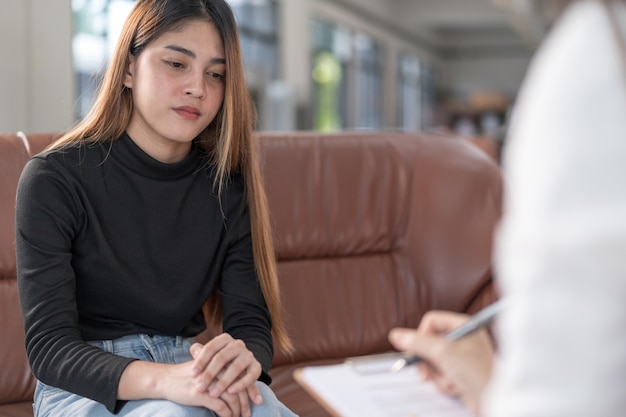 La giovane donna asiatica con problemi di salute mentale incontra lo psicologo per consultare e terapia mentale. Psicologia e concetto di terapia mentale