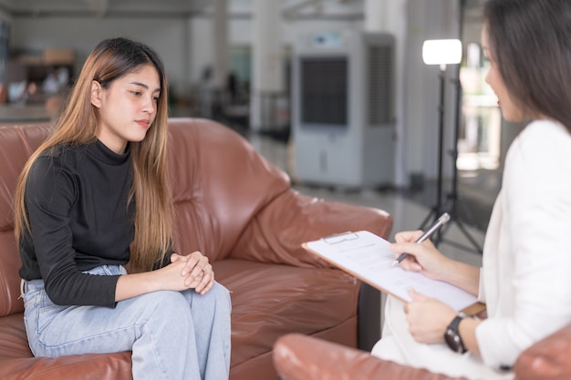 La giovane donna asiatica con problemi di salute mentale incontra lo psicologo per consultare e terapia mentale. Psicologia e concetto di terapia mentale